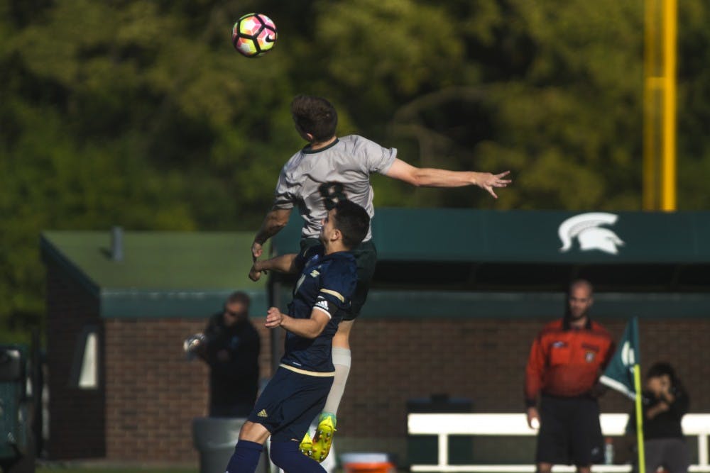 Junior defender Brad Centala (8) heads the ball during the second half of the game on Oct. 11, 2016 at DeMartin Stadium at Old College Field. The Spartans defeated the Zips, 2-1.