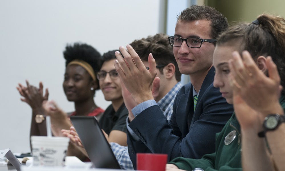 From left to right, Vice President for Academic Affairs Ewurama Appiagyei-Dankah, Vice President for Student Allocations Stephen Brown, Vice President for Finance and Operations Dan Iancio, President Lorenzo Santavicca, Vice President for Internal Administration Katherine Rifiotis clap during an ASMSU meeting on Aug. 27, 2017 at Student Services. ASMSU is the undergraduate student government of MSU.