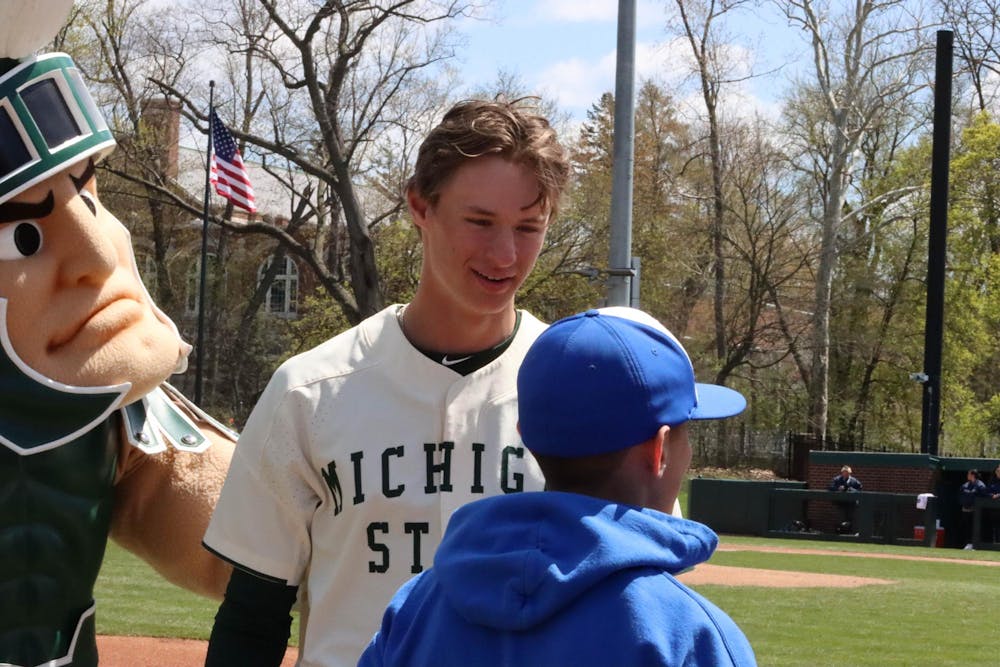 <p>Sophomore infielder Randy Seymour along with Sparty, greet the first pitch guest of the afternoon matchup against Penn State at McLane Baseball Stadium on April 21, 2024.</p>