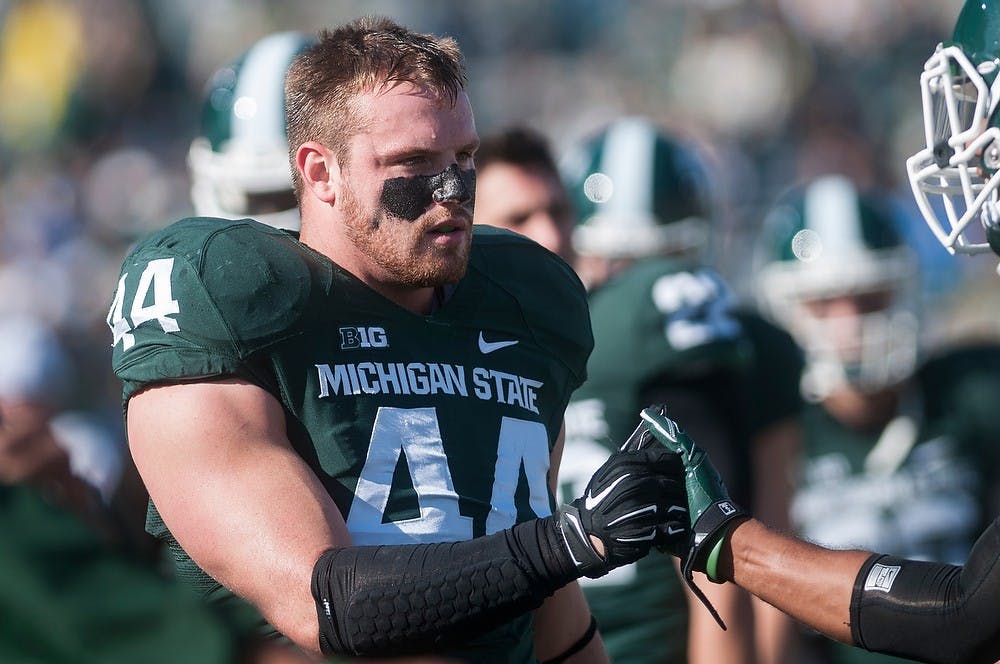 <p>Senior defensive end Marcus Rush shakes hands with  junior snapper Taybor Pepper on Oct. 25, 2014, before the game against Michigan at Spartan Stadium. The Spartans defeated the Wolverines, 35-11. Erin Hampton/The State News </p>