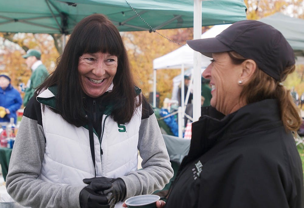 	<p>Troy, Mich., resident Maryann Chaklos and Novi, Mich., resident Cathy Chaklos hold a conversation on Nov. 2, 2013, by Erickson Hall. Tailgating has been a tradition of the Chaklos family since 1975. Georgina De Moya/The State News</p>