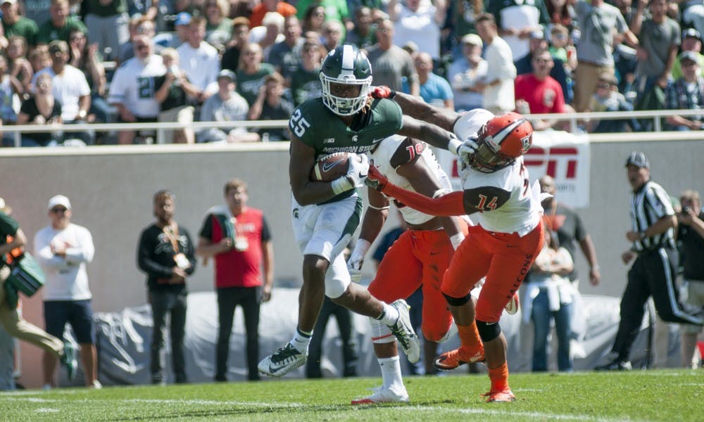 <p>Sophomore wide receiver Darrell Stewart Jr. (25) stiff arms a defender during the game against Bowling Green on Sept. 2, 2017 at Spartan Stadium. The Spartans defeated the Falcons, 35-10.</p>