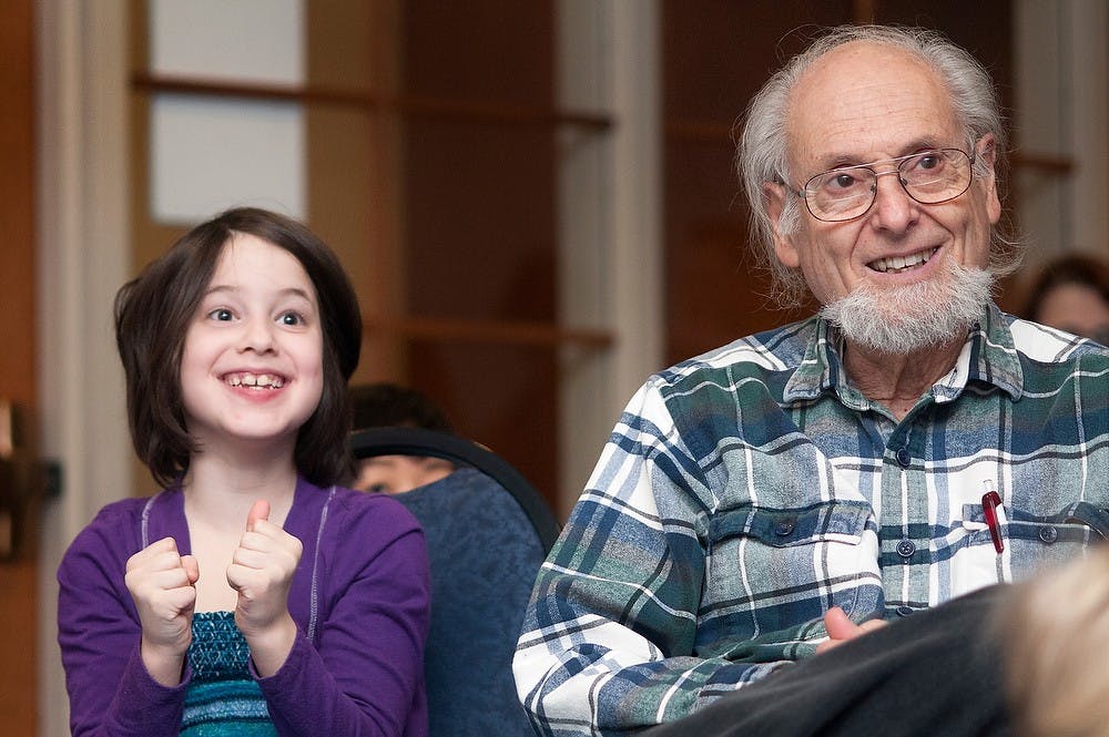 	<p>Eight-year-old Jackie Stein of Benson, Mich., smiles next to her grandfather, Bob Stein, during the children&#8217;s concert Feb. 2, 2013, at Hannah Community Center. Jackie Stein said she was excited she knew the answer to a question asked about a gourd. Natalie Kolb/The State News</p>