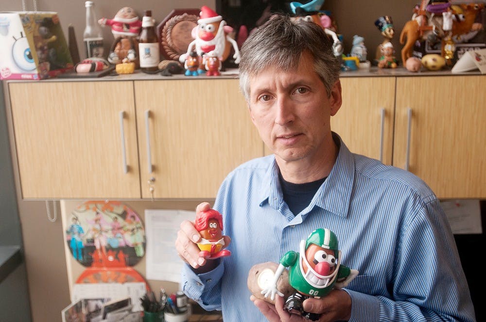 <p>Dave Douches, professor in the Department of Plant, Soil and Microbial Sciences, poses with his potato memorabilia on April 1, 2014, at the Plant and Soil Sciences Building. Douches has studied potatoes for decades and is nationally known for his potato research. Betsy Agosta/The State News</p>