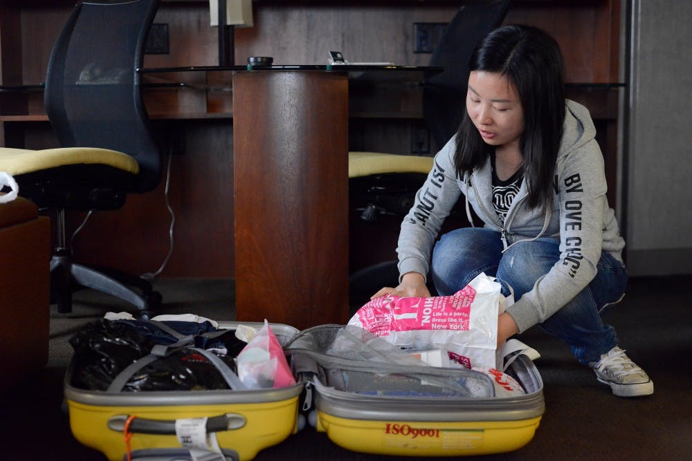 Journalism freshman Xuejia Lai packs her suitcase on Jan. 8, 2016 at Kellogg Center. Due to the dorms being closed over winter break and not being able to fly home, Lai had to stay at the hotel. 