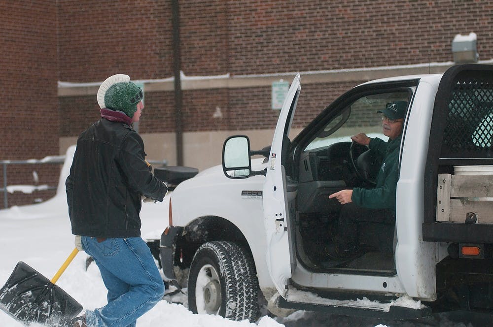 	<p>Landscape Services employee Jim Delinescheff, right, and agribusiness management junior Joseph Drent discuss snow removal efforts on Jan. 6, 2014, near the <span class="caps">MSU</span> Union. Drent shoveled snow around entrances to the Union. Christina Strong/The State News</p>