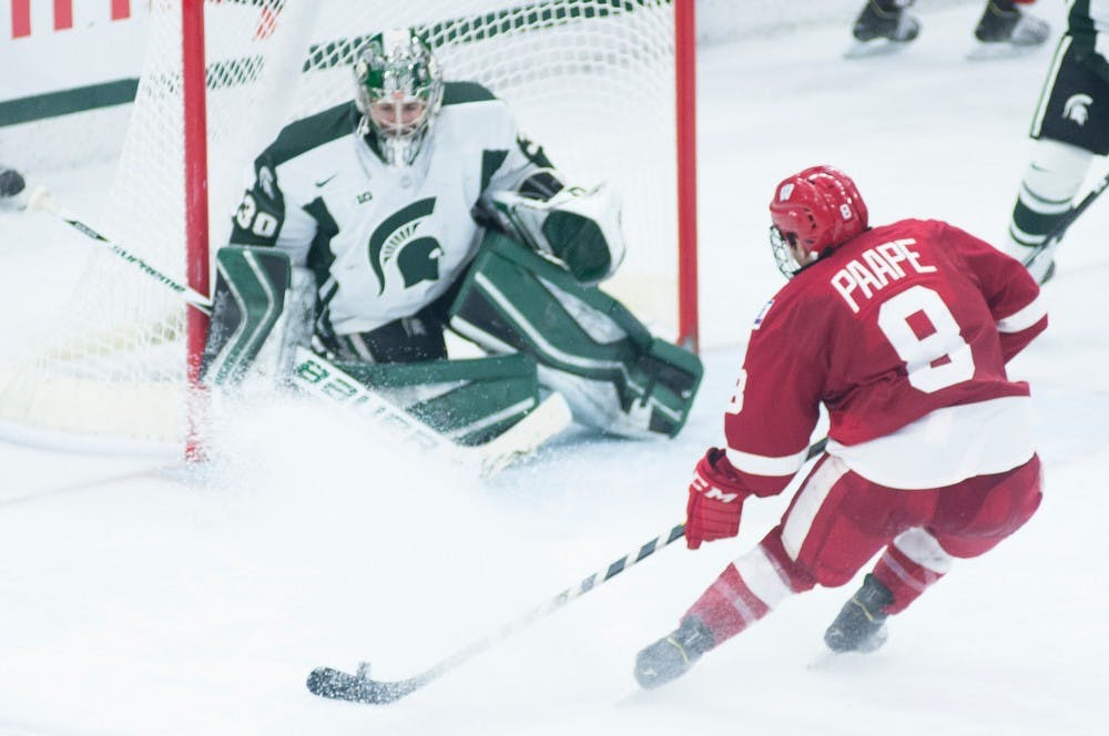 <p>Junior goaltender Jake Hildebrand blocks Wisconsin sophomore left wing Morgan Zulinick's shot March 6, 2015, during the game against Wisconsin at Munn Ice Arena. The Spartans defeated the Badgers 3-0. Kennedy Thatch/The State News</p>