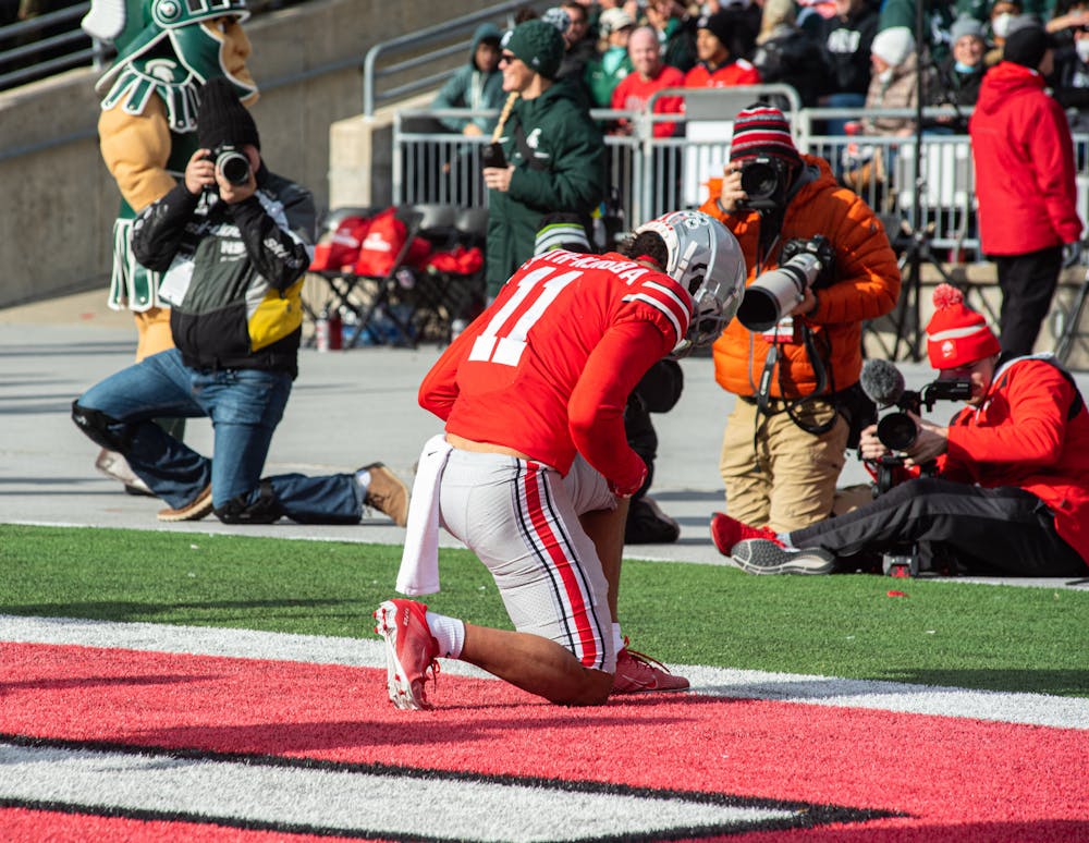 <p>Ohio State&#x27;s Jaxon Smith-Njigba (11) kneals in the endzone after completing a touchdown on Nov. 20, 2021.</p>