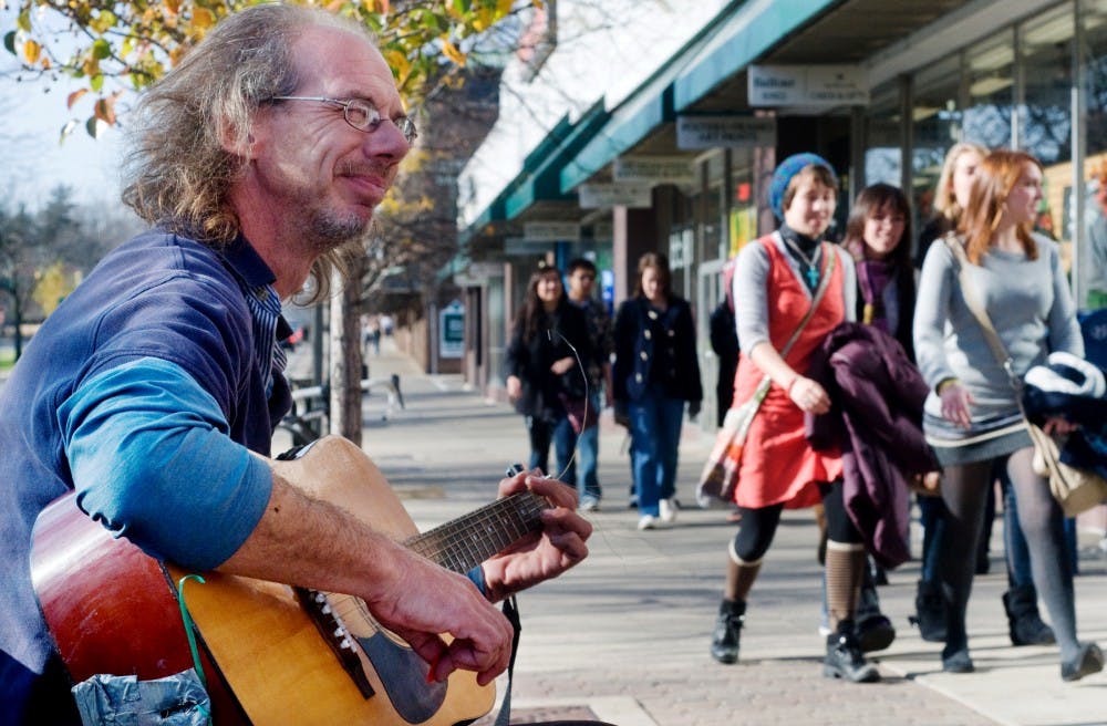 Graham Robertson, a street musician of East Lansing strums his guitar on Saturday afternoon on Grand River. Anthony Thibodeau/The State News