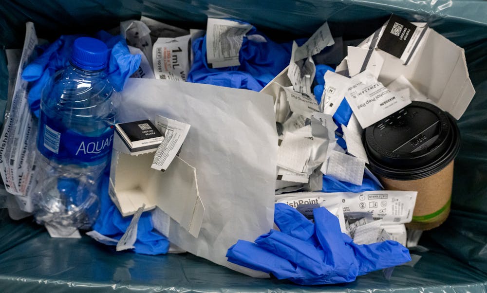 <p>Trash at the COVID-19 vaccine booster clinic at the Breslin Center on Jan. 26, 2022. The gloves and wrappers demonstrate repetitiveness for the volunteers and workers at the clinic.</p>