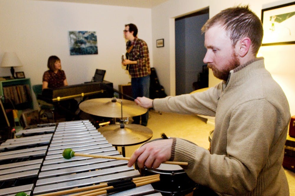 Keyboardist and vocalist Bethany Foote, guitarist and vocalist Brandon Foote, and percussionist Ty Forquer of Gifts and Creatures practice for their upcoming show. Gifts and Creatures play with Michigan folk band Breathe Owl Breathe on January 14th. Derek Berggren/The State News