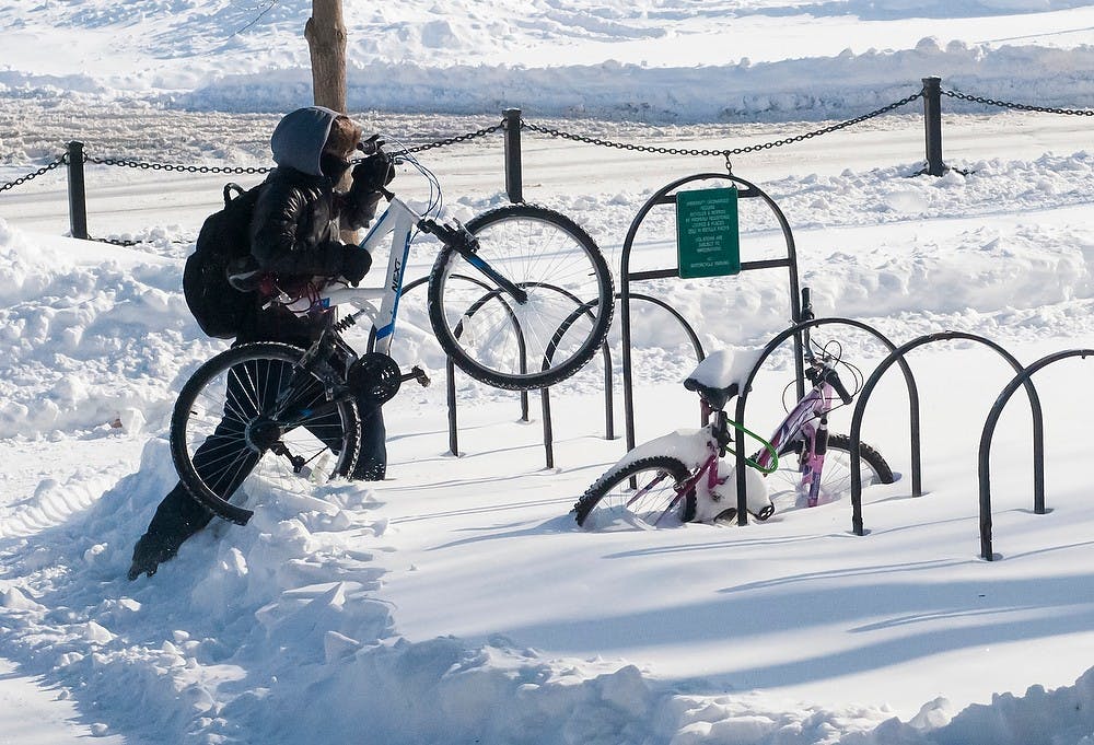 	<p>Natural resource recreation and tourism junior Shane Paeth tries to find a place to park his bike, Jan. 7, 2014, at Bessey Hall. Many bikes and cars on campus were snowed in. Erin Hampton/The State News </p>