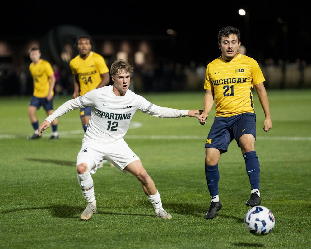 <p>Michigan State University junior midfielder Cristiano Bruletti (12) and University of Michigan graduate forward Beto Soto (21) watch the ball at the MSU vs. UOM men’s soccer match at DeMartin Stadium on Oct. 22, 2024.</p>