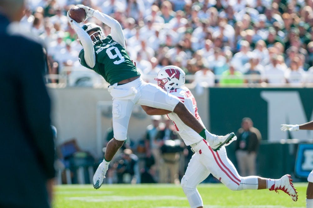 Freshman wide receiver Donnie Corley (9) catches a pass while being covered by Wisconsin safety Arrington Farrar (21) during the game against Wisconsin on Sept. 24, 2016 at Spartan Stadium. Corley caught a total of four passes for 84 yards.