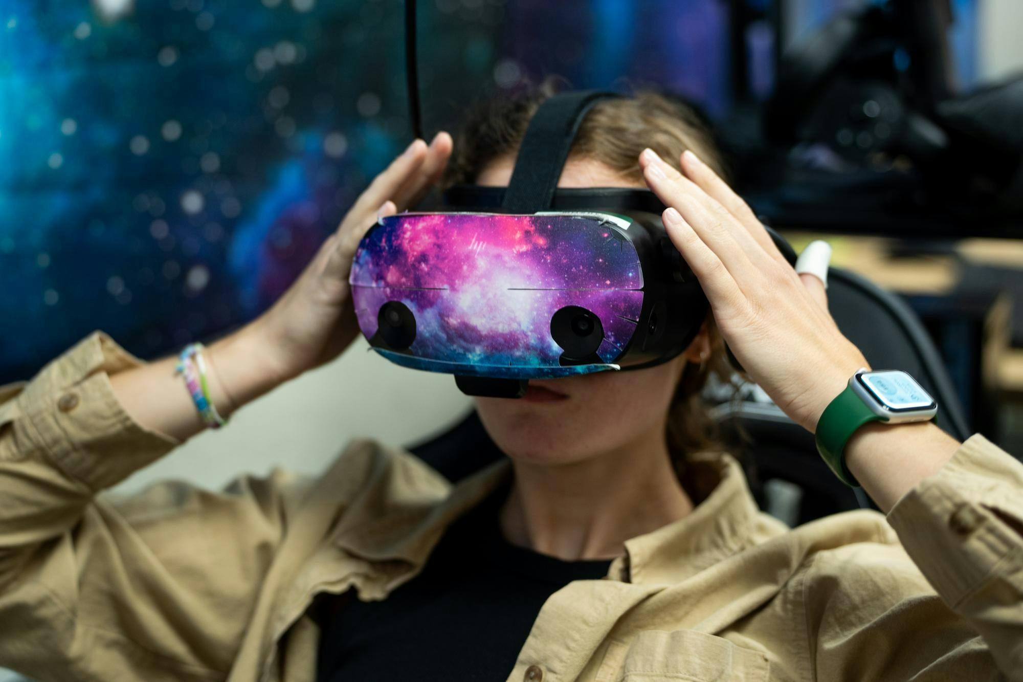 <p>Grace Thomas, an undergraduate research assistant, dons the virtual reality headset during a demonstration of the lab's research methods in the Communication Arts and Sciences building on Michigan State University's campus, Aug. 9, 2024. The lab uses virtual reality and other integrated technologies to research communication disabilities in children, like stuttering.</p>