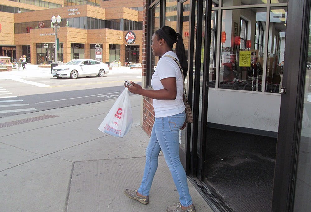 <p>Criminal justice sophomore Brianna Harris walks out of CVS Pharmacy, 240 M.A.C. Ave., after some quick grocery shopping.</p>