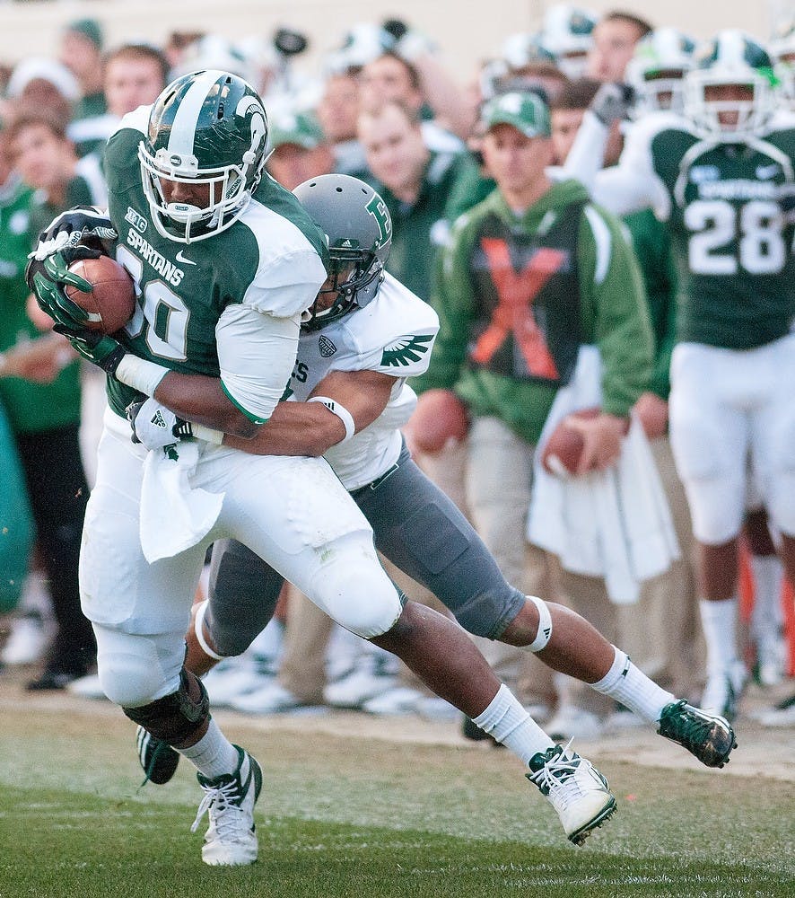 	<p>Defensive back Donald Coleman attempts to bring down senior tight end Dion Sims on Saturday, Sept. 22, 2012 at Spartan Stadium. Sims finished the game with 112 receiving yards and one touchdown. James Ristau/The State News</p>