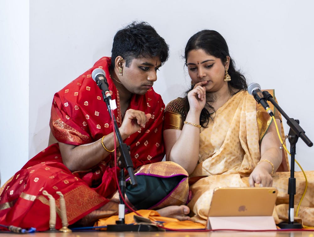 Abhinav Anand’s violinist and close friend Deekshitha Balaji looks over his music before his performance at the Sri Sharadamba Temple in Farmington Hills, Mich., on March 8, 2026. “He teaches me a lot,” Balaji said. “When I'm watching him dance, it makes it even better because I actually understand what he's dancing.” 