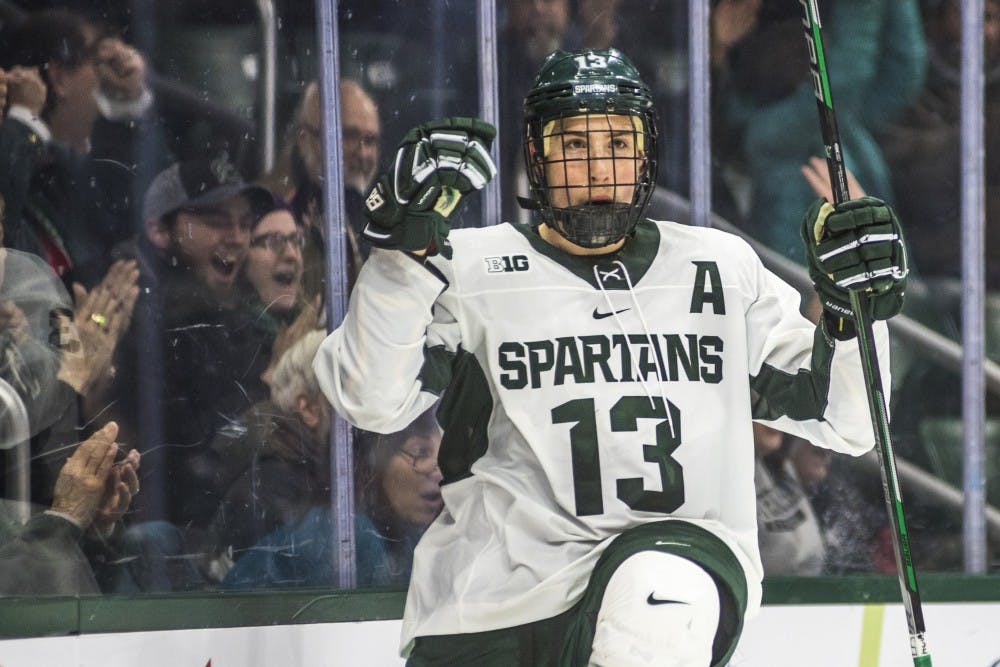 Junior left wing Brennan Sanford (13) celebrates after scoring a goal during the men's hockey game against Ohio State on Jan. 5, 2018 at the Munn Ice Arena. The Spartans were defeated by the Buckeyes, 4-1. (Nic Antaya | The State News)