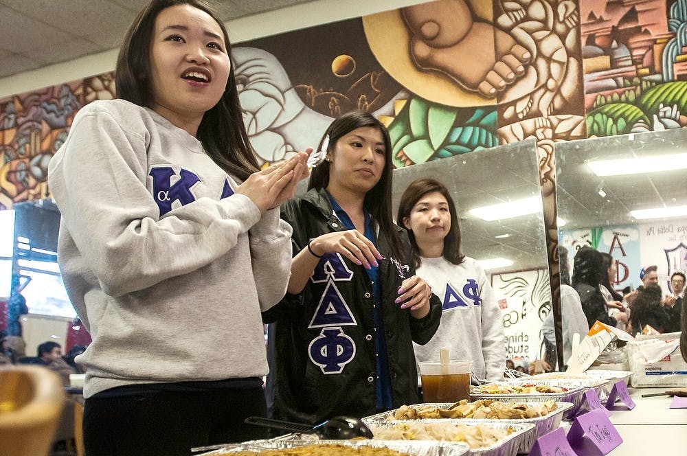<p>Hospitality business sophomore Chelsea Chiu gets ready to serve Asian cuisine April 15, 2014, at the "Taste of Asia" event in Holden Hall. The event served all kinds of authentic Asian cuisine. Erin Hampton/The State News</p>