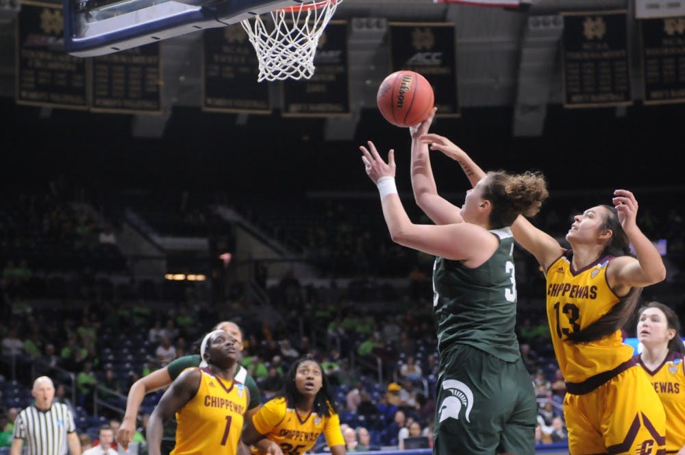 <p>Senior center Jenna Allen lays the ball up while being guarded by Central Michigan  forward Reyna Frost</p>