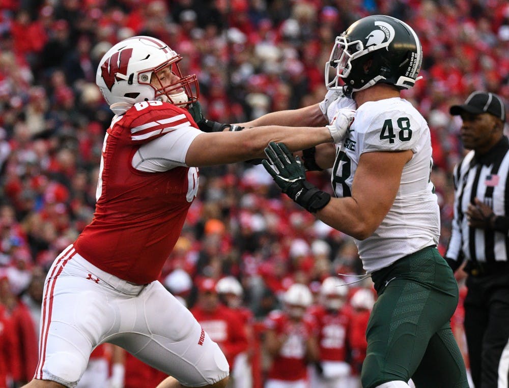 <p>Senior defensive end Kenny Willekes (48) blocks a Wisconsin player during the game against Wisconsin at Camp Randall Stadium on October 12, 2019. The Spartans lost to the Badgers 38-0. </p>