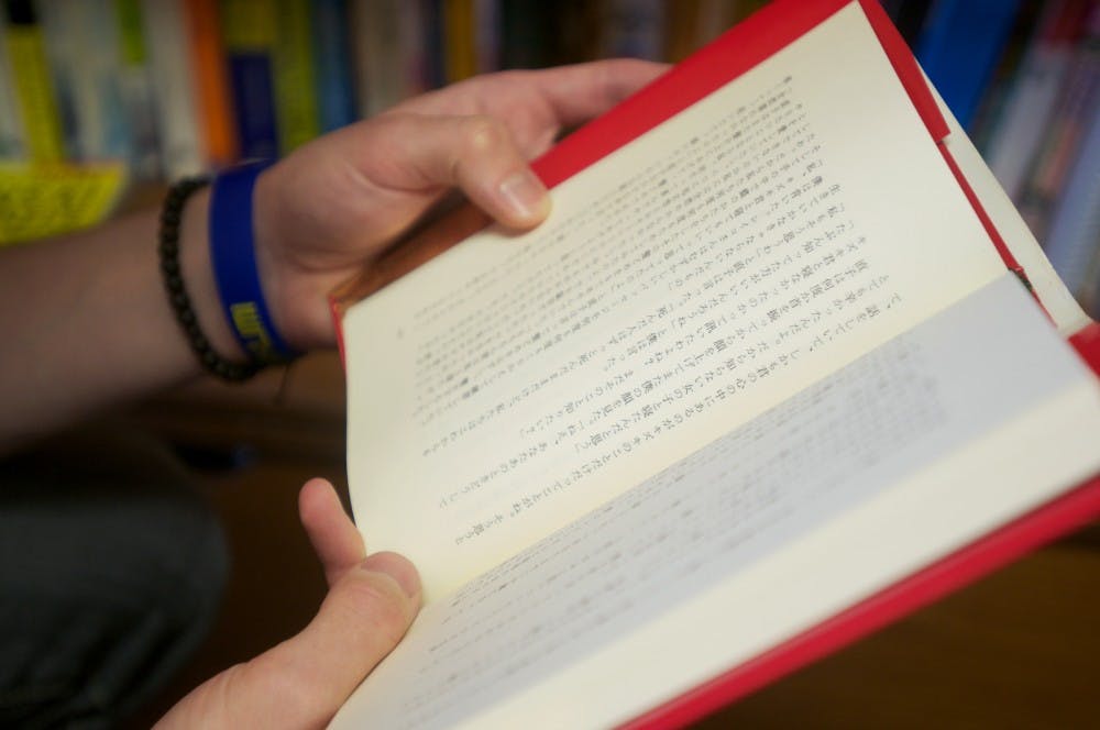 Japanese junior Joseph Canty shows off a famous Japanese novel called "Norwegian Wood". It's just one book of many in his collection of Japanese books. Griffin Zotter/The State News