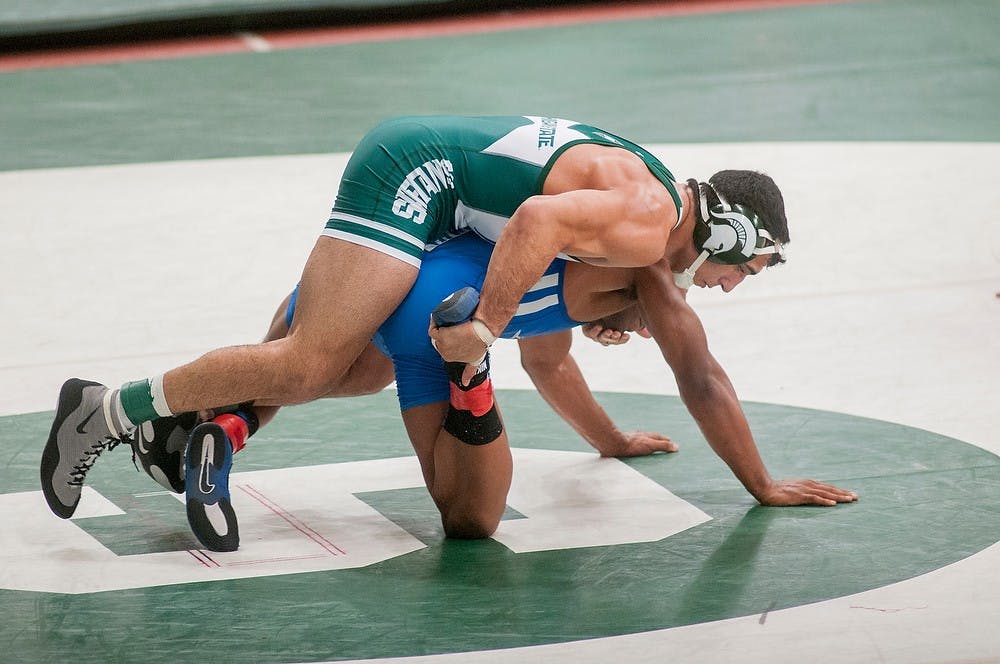 	<p>Junior Mike McClure tries to pin Theodore Furnish of Lindsey Wilson College on Sunday, Nov. 11, 2012, at Jenison Fieldhouse. The two were competing in the Michigan State Open wrestling tournament. James Ristau/The State News</p>