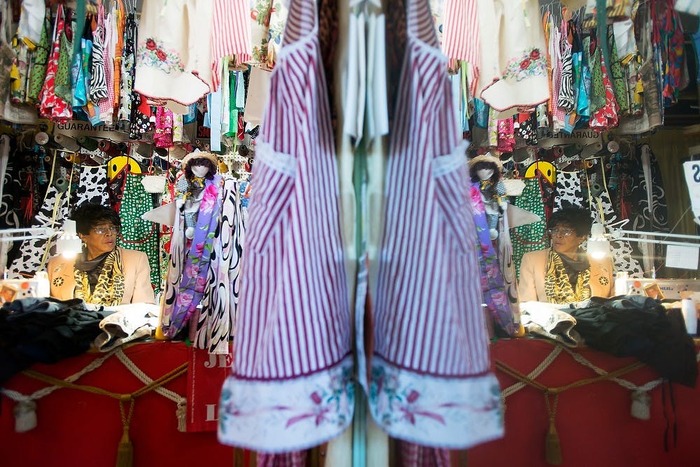 	<p>Lansing resident Elizabeth McMurray looks up from her work at her favorite soap opera program Nov. 13, 2013, at her alteration shop, 1810 E. Michigan Ave. McMurray has dozens of aprons hanging in her shop, a project she started in 2010 as a way to promote family unity by bringing children into the kitchen with their moms and dads. Julia Nagy/The State News</p>