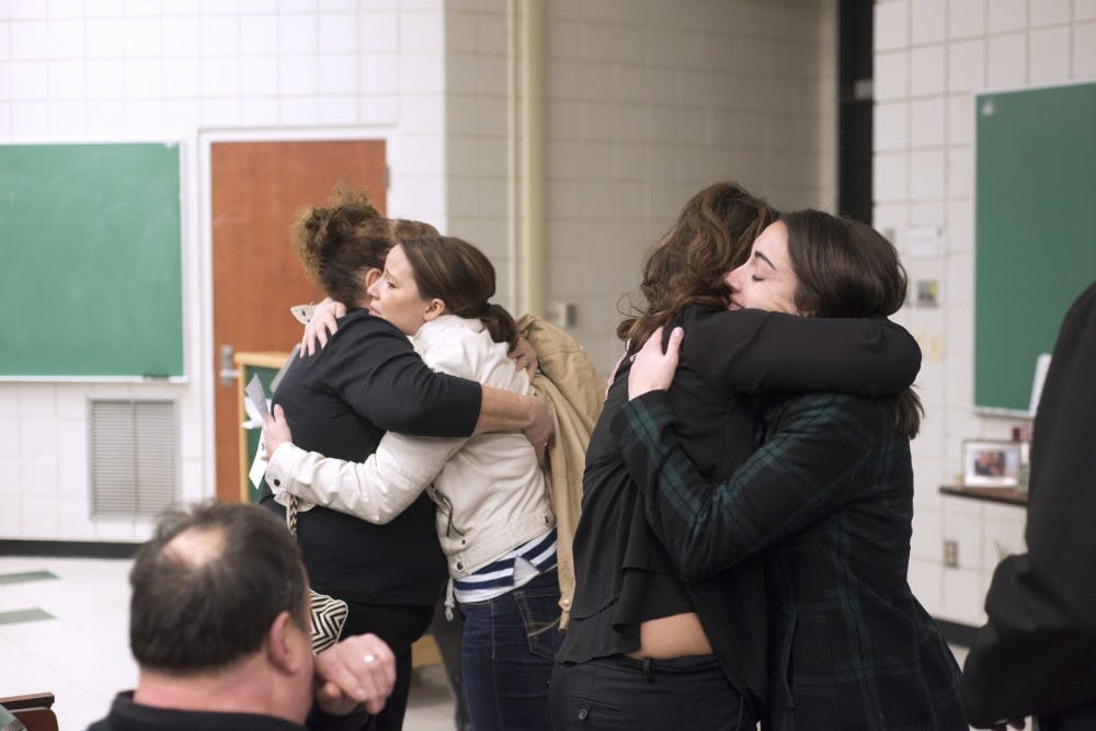 Friends and family console Heather LaBerge, fianc?e of Max Monroy-Miller, who passed away earlier this week. Photo taken March 17, 2016 during a vigil at South Kedzie Hall.