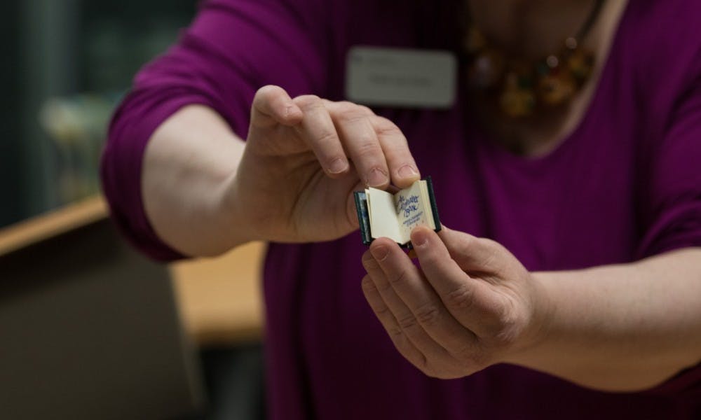 Ruth Ann Jones, the special collections education and outreach librarian, holds the library's smallest book at the Special Collections Seminar Room at the Main Library on Jan. 11, 2019. The smallest book, "An Alphabet Book", was published in 1980.