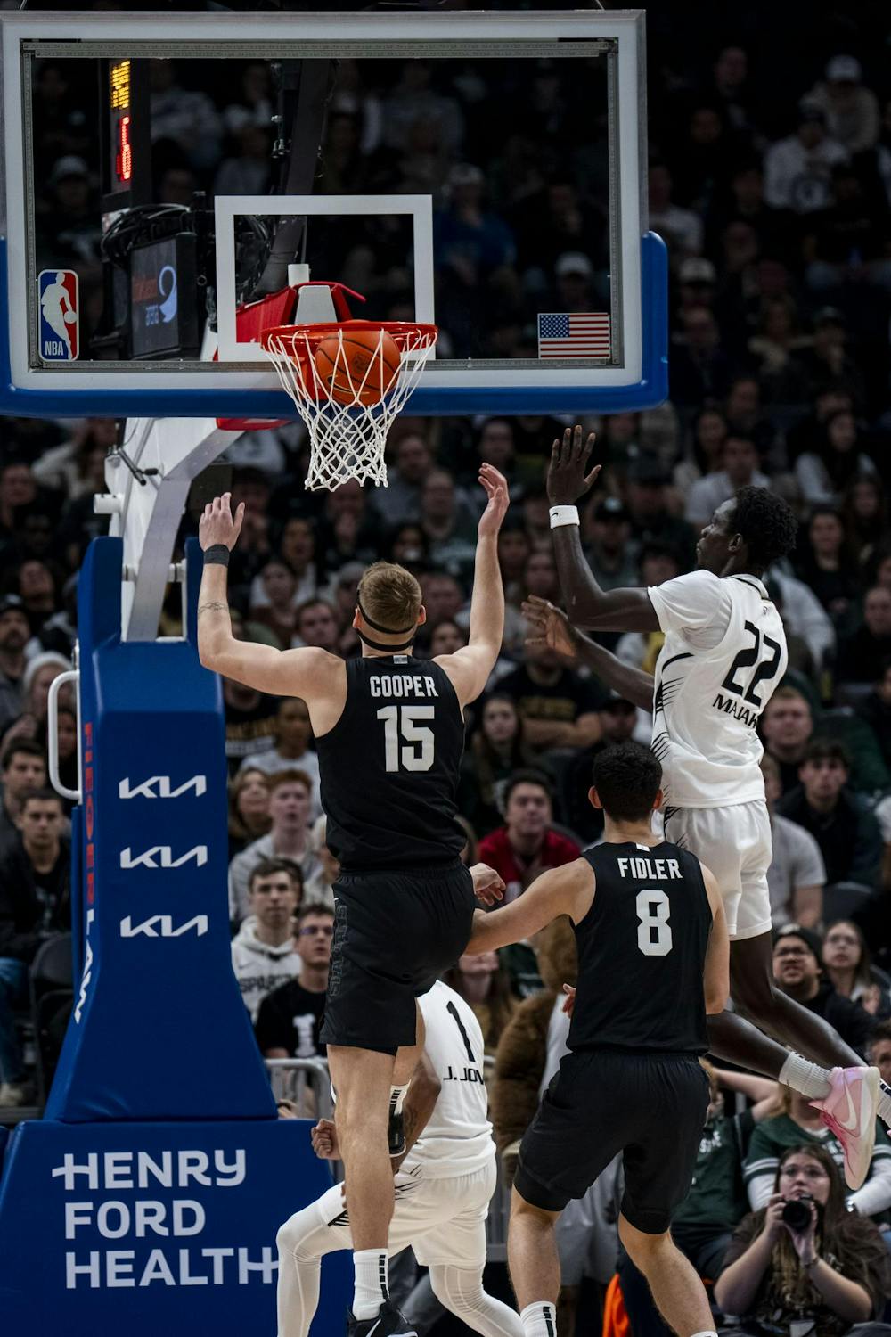 <p>Michigan State junior center Carson Cooper (15) runs to catch the ball after Oakland junior forward Deng Majak (22) makes a basket at Little Caesars Arena in Detroit on Dec. 17, 2024. The Spartans defeated the Golden Grizzlies 77-58.</p>