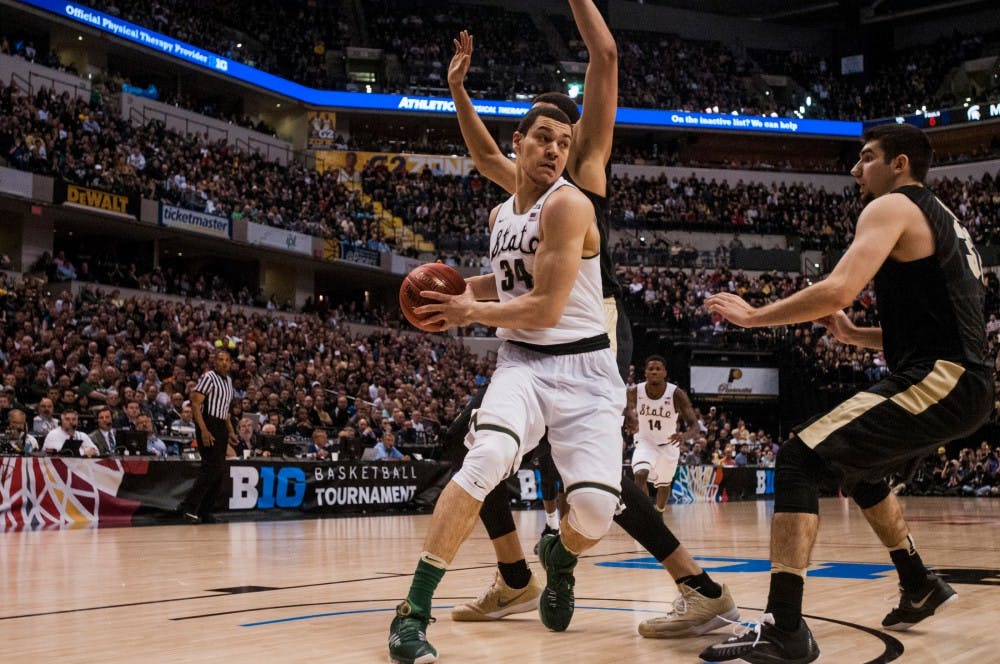 Junior forward Gavin Schilling looks to pass over Purdue guard Dakota Mathias during the second half of the game on March 13, 2016 at Bankers Life Fieldhouse in Indianapolis, Indiana. The Spartans defeated the Boilermakers, 66-62. 
