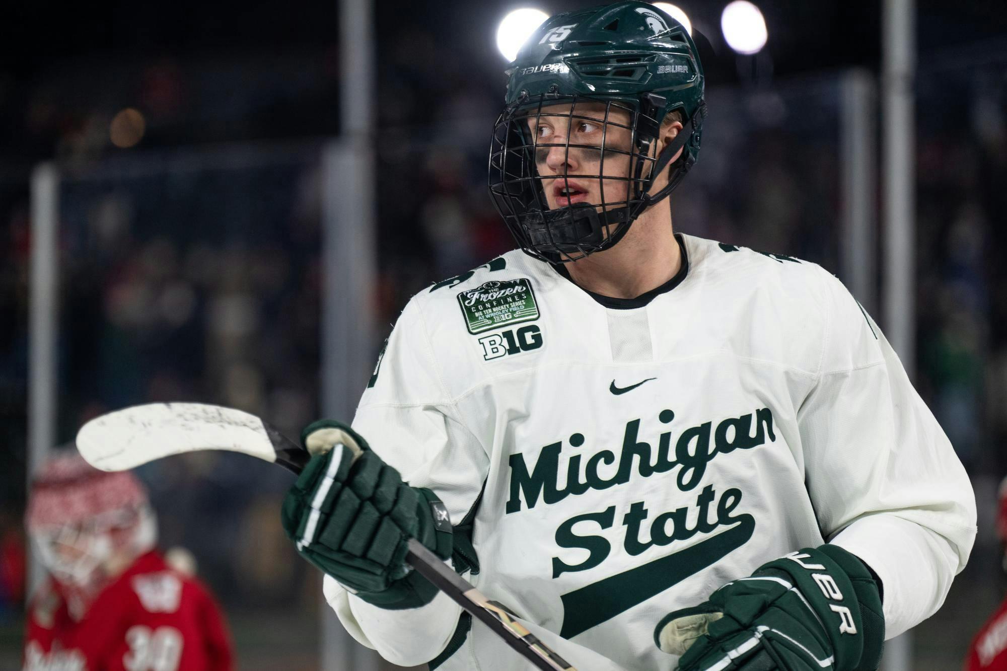 Michigan State junior forward Charlie Stramel (15) skates to the faceoff dot at Wrigley Field in Chicago on Jan. 4, 2025. The Spartans' junior forward Daniel Russell (20) netted the overtime winner with under two seconds remaining, earning the weekend sweep over the Badgers.