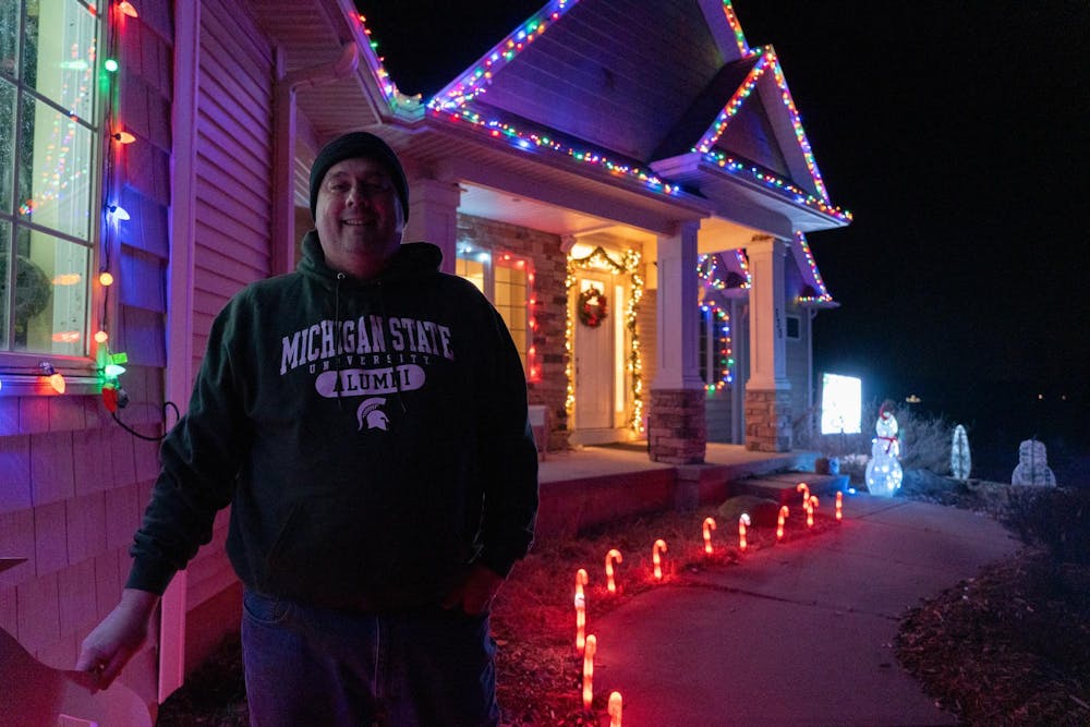 Josh Tkaczyk poses in front of his house near Mason, Michigan, on Thursday, Dec. 7, 2023. Tkaczyk's house is covered in Christmas decorations and a speaker plays Christmas music that syncs up with the lightshow.
