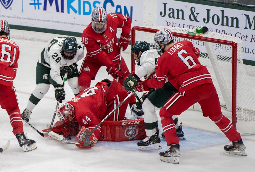 <p>Freshman forward Tanner Kelly (26) fights to shoot the puck into the Ohio State goal during the second period. The Spartans fell to the Buckeyes, 4-1, at Munn Ice Arena on Jan. 21, 2022. </p>