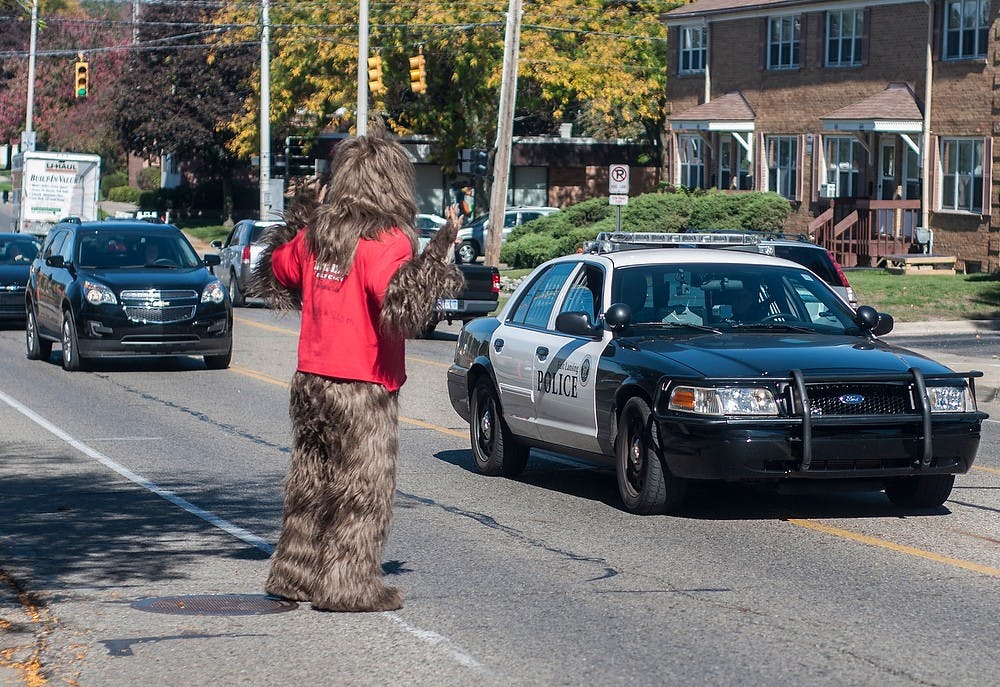 	<p>Sasquatch wanders into traffic and puts his hands up as a police car drives past Oct. 11, 2013, on Abbot Road. Sasquatch roamed the streets of East Lansing before the Homecoming parade.</p>