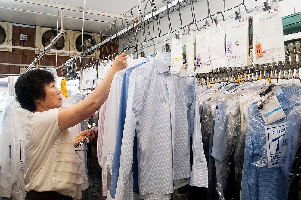 <p>Okemos, Mich., resident Mesung Lee performs her daily duties on August 1, 2014, at Twichell's Dry Cleaners & Tailors on M.A.C. There busiest time of the year is when MSU students return in the fall. Jessalyn Tamez/The State News</p>