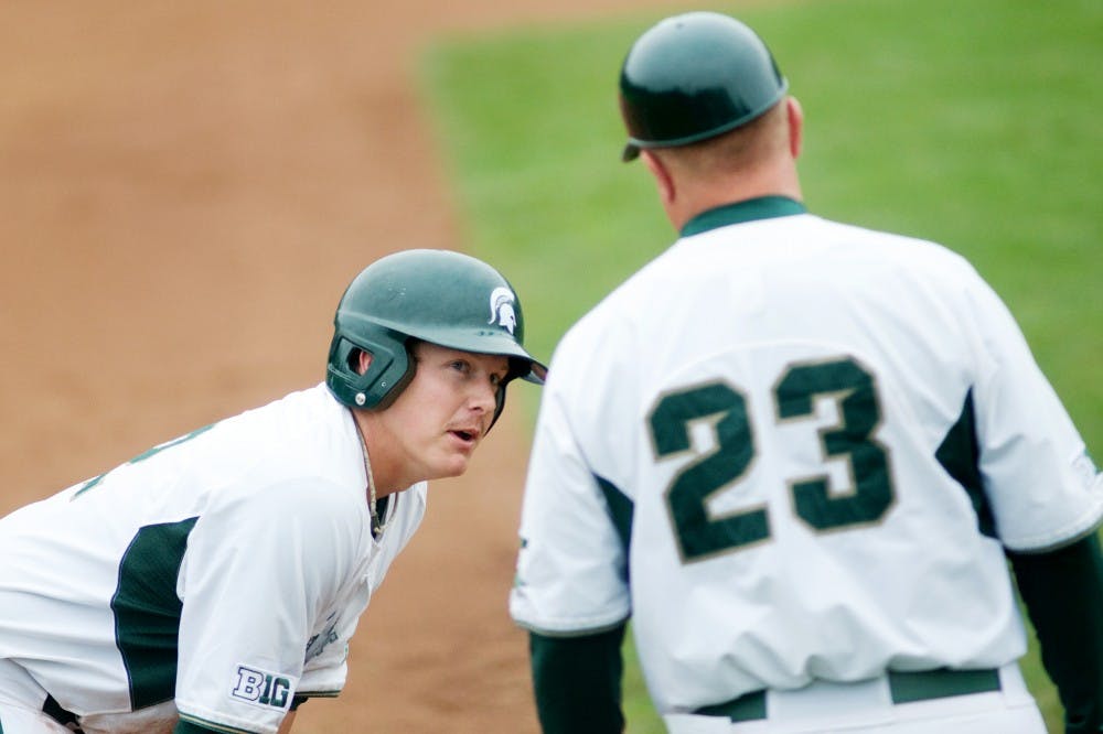 Junior infielder and outfielder Jared Hook talks with head coach Jake Boss JR. on third base Saturday afternoon at McLane Baseball Stadium. The Spartans defeated Oakland University 11-2 in the second game of the series. Jaclyn McNeal/The State News
