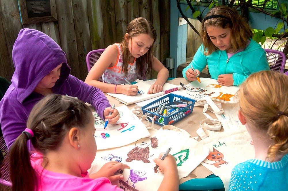 <p>Campers color their own tote bags on August 5, 2014, at the Children's 4-H Garden on Bogue street. Camp Monet is a three day camp where campers take inspiration from the garden to make creative projects. Jessalyn Tamez/The State News</p>
