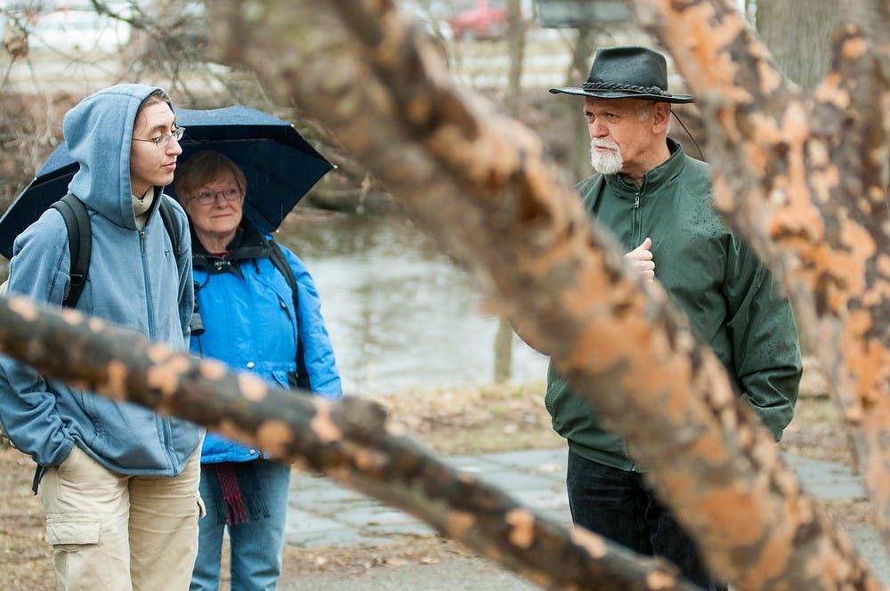 <p>Microbiology junior Michelle Gross, left, listens as assistant curator of Beal Botanical Garden Peter Carrington leads a tour as part of engineering week April 3, 2014, at the Beal Botanical Garden behind the library. Carrington lead a walking tour to point out flowers that were beginning to bloom. Danyelle Morrow/The State News</p>