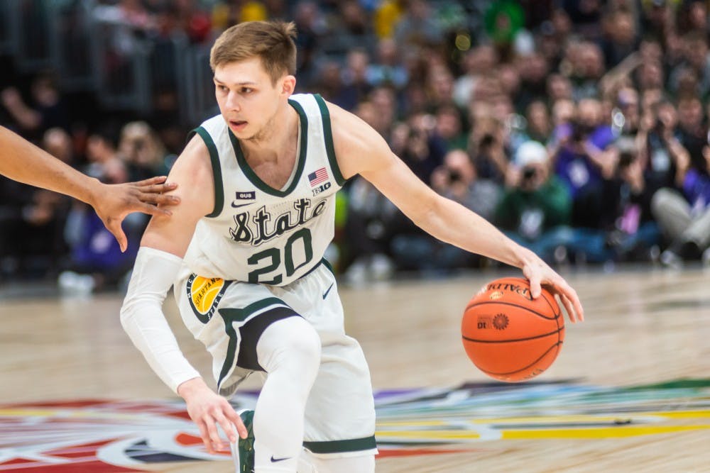 <p>Then-senior guard Matt McQuaid (20) dribbles the ball against Michigan. The Spartans beat the Wolverines, 65-60, at the United Center on March 17, 2019.</p>