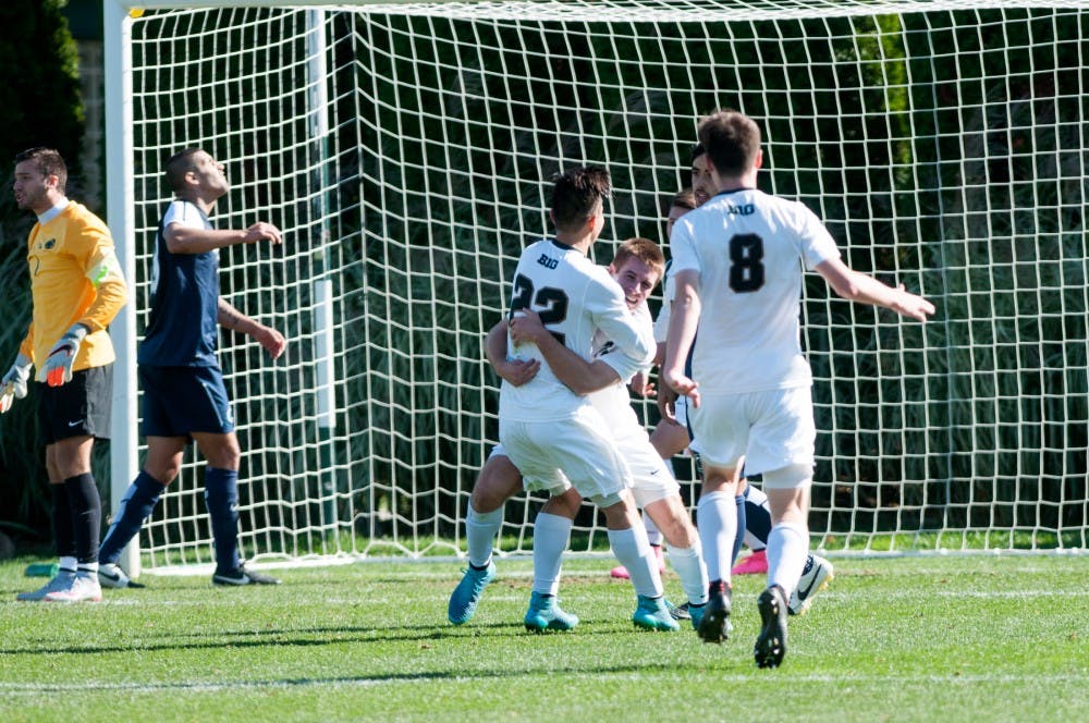 <p>Sophomore midfielder Ken Krolicki embraces freshman defender Connor Corrigan after Corrigan made the Spartan's second goal during the Men's Soccer game against Penn State on Oct. 18. 2015 at the DeMartin Soccer Complex. The Spartans defeated the Nittany Lions, 2-1. </p>