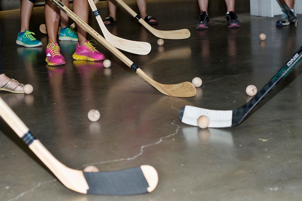 <p>Women practice passing balls back and forth with each other Sept. 3, 2014, during a women's hockey clinic at Munn Ice Arena. Women were able to take their hockey sticks home with them after the clinic,  and it was open for anyone who wanted to join. Erin Hampton/The State News</p>
