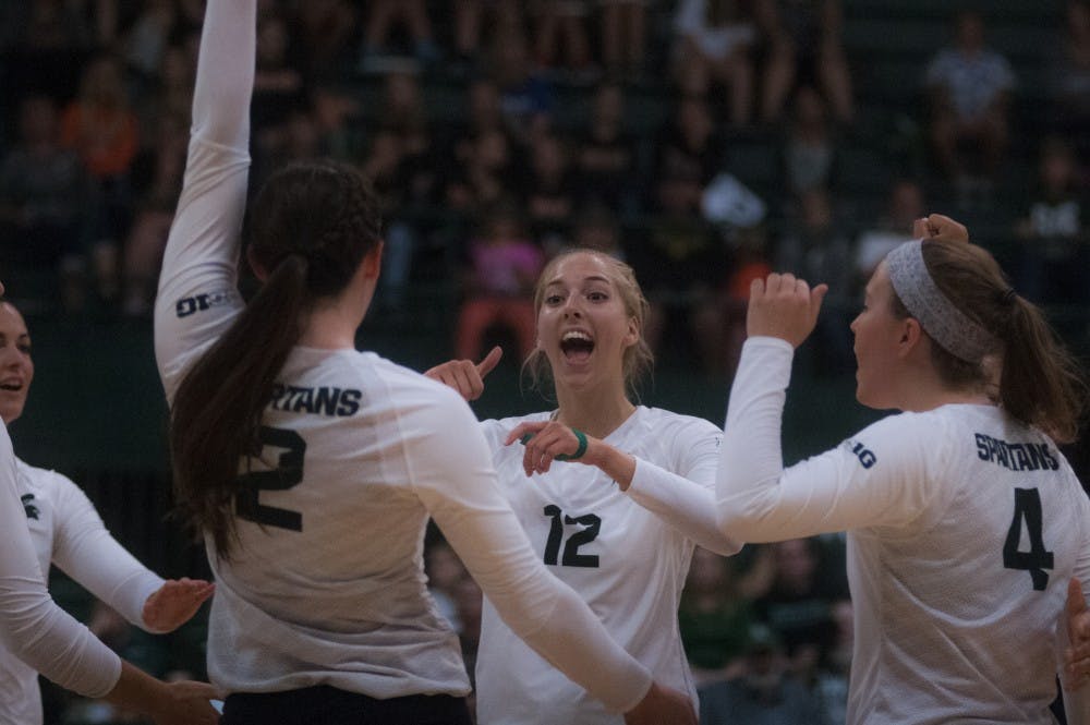 Junior setter Rachel Minarick (12) celebrates with her teammates during the volleyball game against Notre Dame on Sept. 16, 2016 at the Jenison Field House. The Spartans defeated the Fighting Irish, 3-0. 