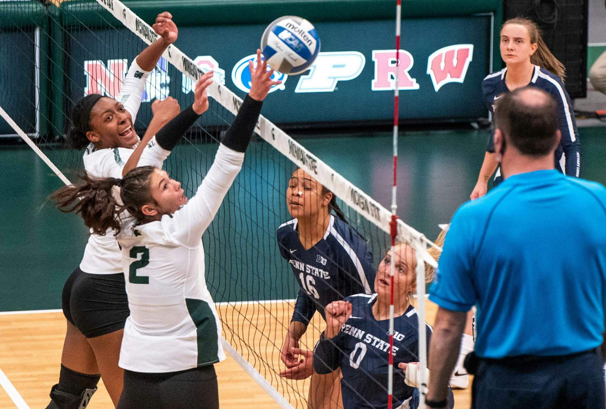 <p>Freshman setter Celia Cullen (2) and junior middle blocker Naya Gros (17) block the ball in the first set against Penn State. The Nittany Lions shut out the Spartans, 3-0, on March 20, 2021. </p>