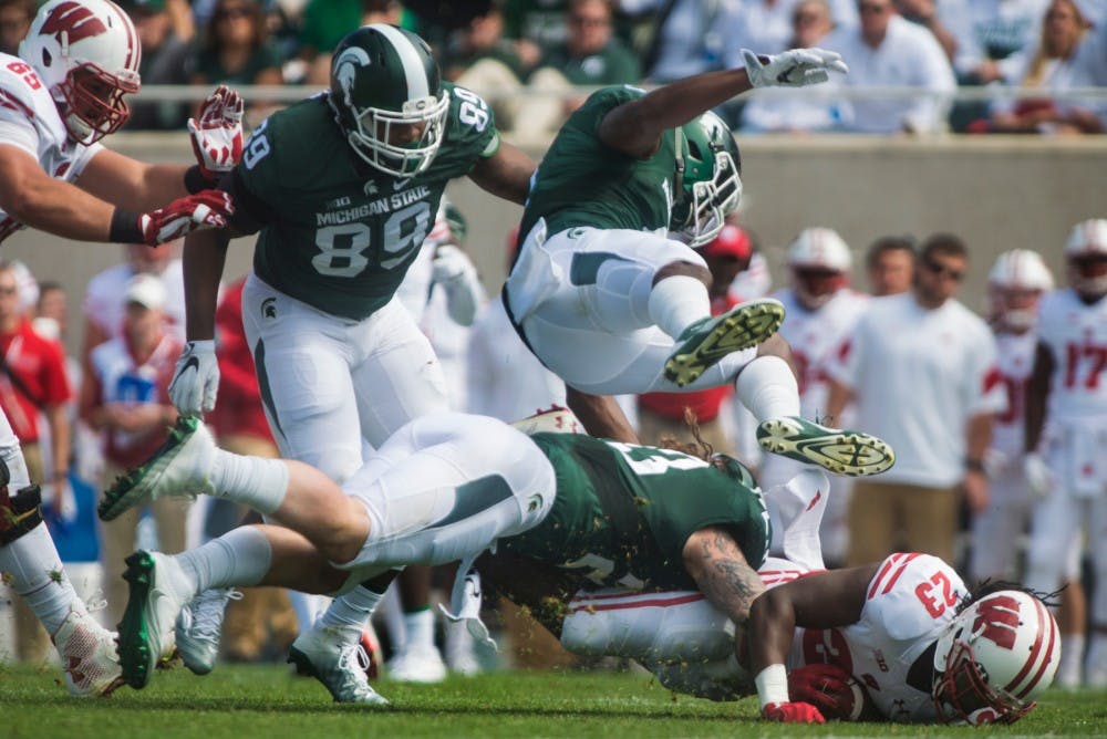 Junior linebacker Chris Frey (23) tackles Wisconsin running back Dare Ogunbowale (23) during the first half of game against Wisconsin on Sept. 24, 2016 at Spartan Stadium.