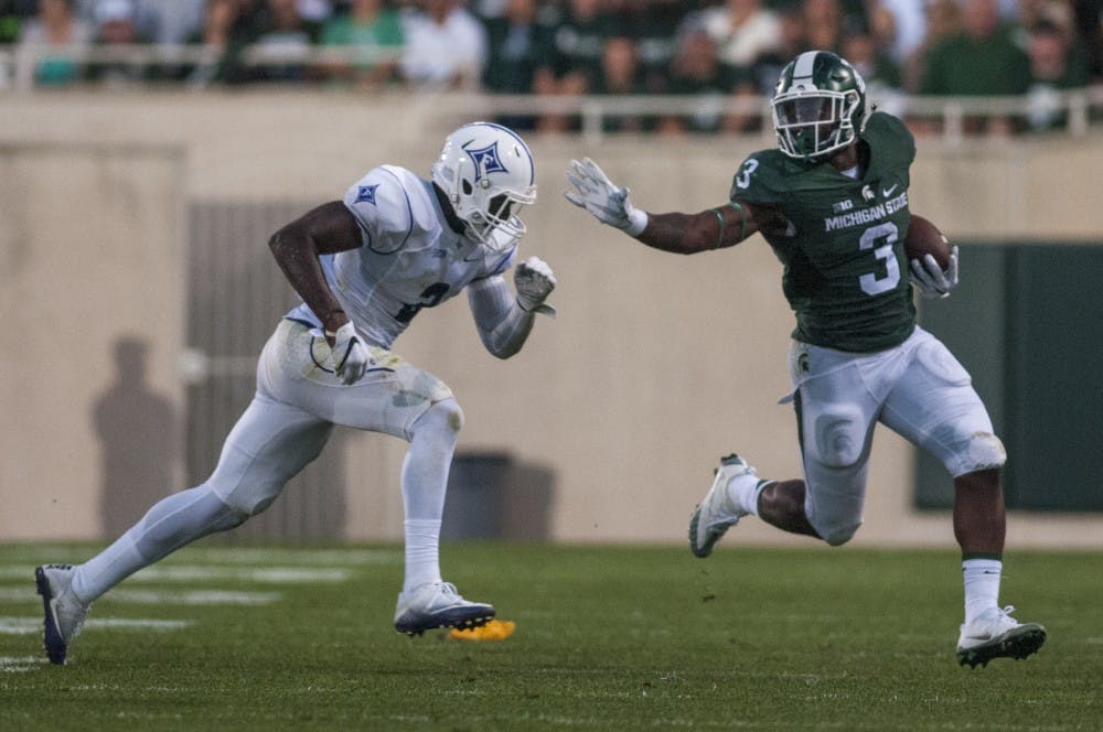 Sophomore running back LJ Scott (3) puts his arm out for a stiff arm against Furman safety Trey Robinson (2) during the first half of the home football game against Furman on Sept. 2, 2016 at Spartan Stadium. 