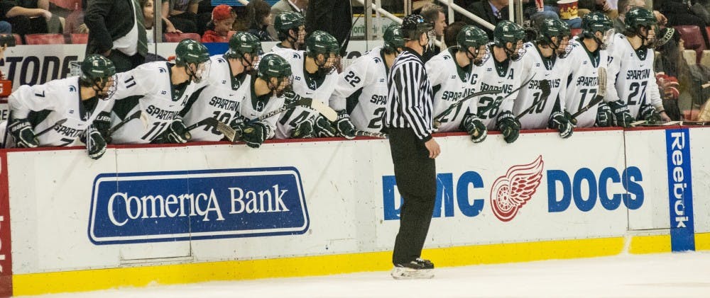 The Spartans lean over to watch a play unfold during the third period of the 52nd Annual Great Lakes Invitational third-place game against the University of Michigan on Dec. 30, 2016 at Joe Louis Arena in Detroit. The Spartans were defeated by the Wolverines in overtime, 5-4.