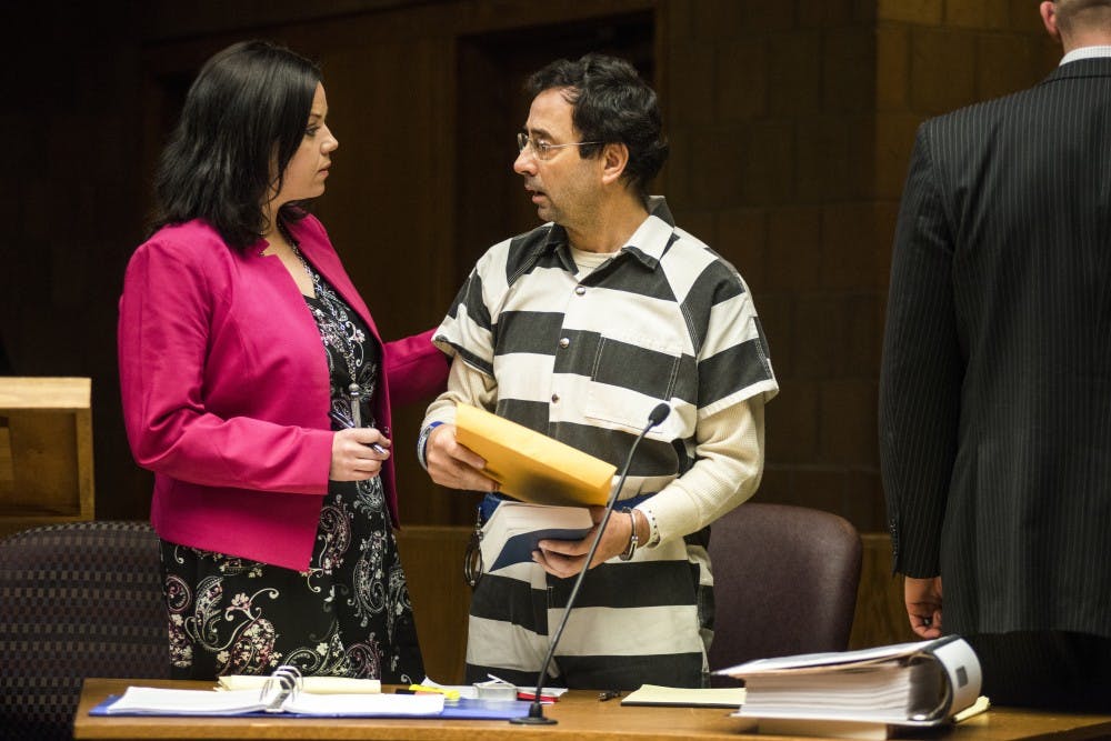 Defense attorney Shannon Smith comforts her client, former MSU employee Larry Nassar, during the preliminary examination on Feb. 17, 2017 at 55th District Court in Mason, Mich. The preliminary examination occurred as a result of former MSU employee Larry Nassar's alleged sexual abuse.